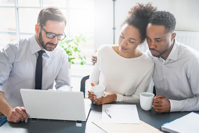 couple looking at computer screen with business professional